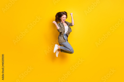 Full length body size view of attractive cheerful lucky girl jumping rejoicing success isolated over bright yellow color background