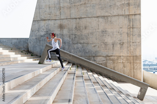 Sportswoman jogging on staircase photo