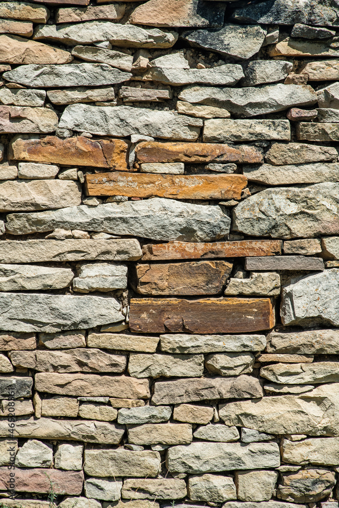 Fototapeta premium Masonry wall of old stone blocks of limestone. Background texture of ancient brick wall