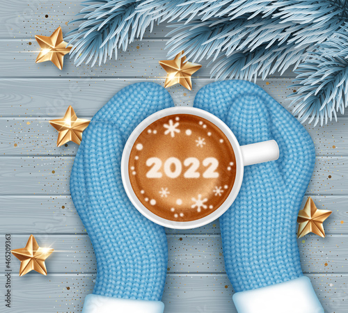 Hands in knitted mittens holding a cup of coffee. New Year greeting card template