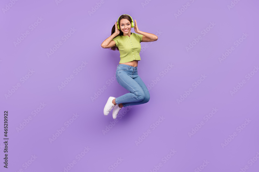 Full length body size view of pretty cheery girl jumping listening hit melody having fun isolated over purple violet color background