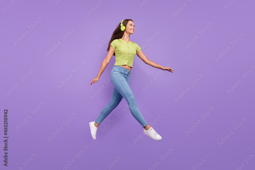 Full length body size view of pretty cheery girl jumping listening melody going isolated over purple violet color background
