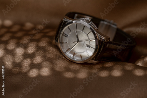Mechanical wristwatch with manual winding on brown background
