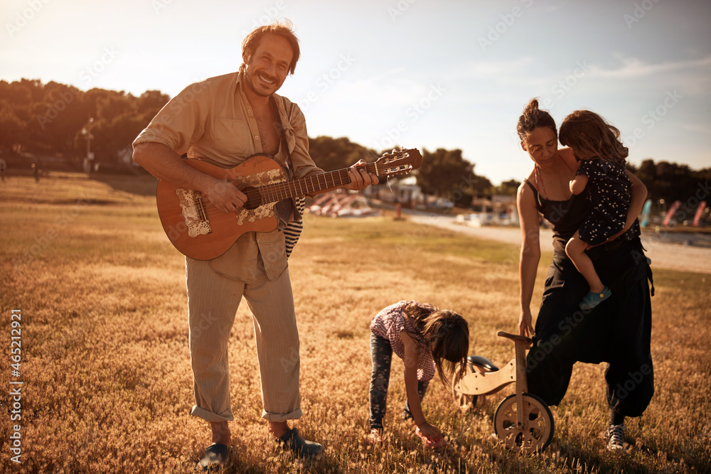 Family on a vacation, singing, playing music on a guitar and enjoying summertime vibes. Family on a vacation, singing, playing music on a guitar and enjoying summertime vibes.