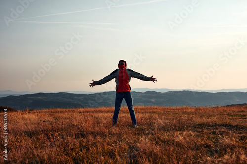 Man enjoying on a mountain hill top with panoramic landscape view. © astrosystem