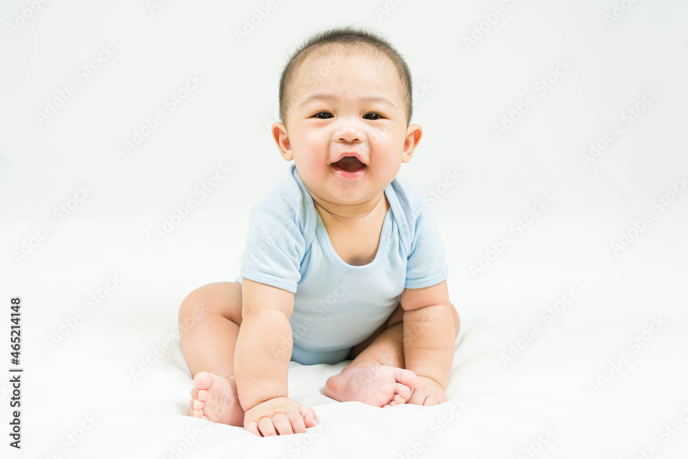childhood and Childcare concept Portrait of cute little 5 months old asian newborn baby boy wearing blue bodysuit sitting and smiling on white beedsheets.Selective focus. childhood and Childcare concept Portrait of cute little 5 months old asian newborn baby boy wearing blue bodysuit sitting and smiling on white beedsheets.Selective focus.