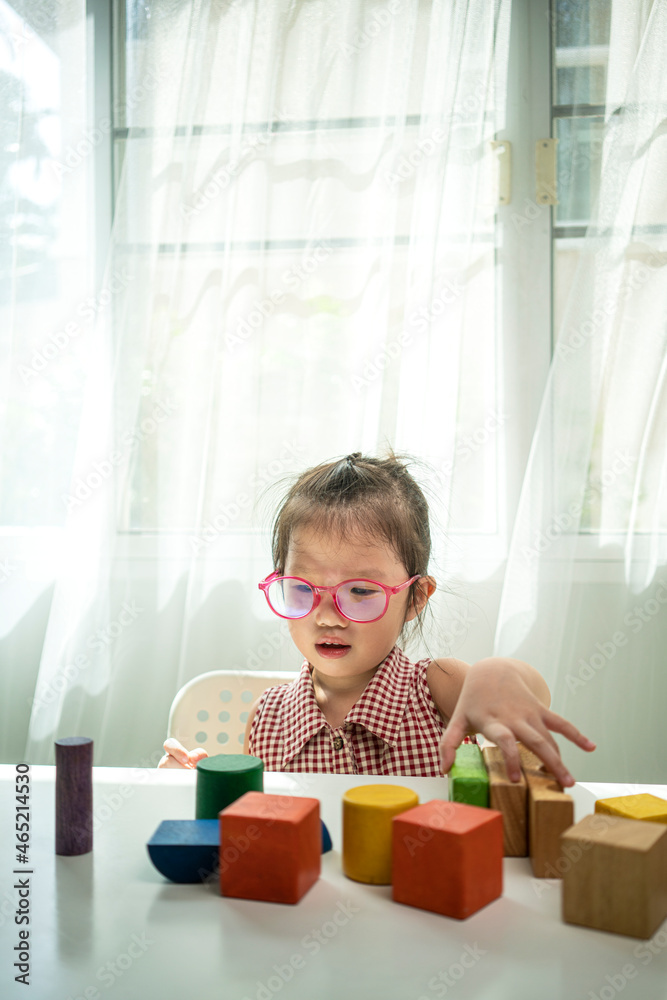 Asian girl playing wooden block toy in living room at home. Asian family and kids concepts Asian girl playing wooden block toy in living room at home. Asian family and kids concepts