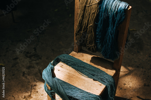 Indigo-dyed threads on a wooden chair. Cotton that has been dyed in its natural color.