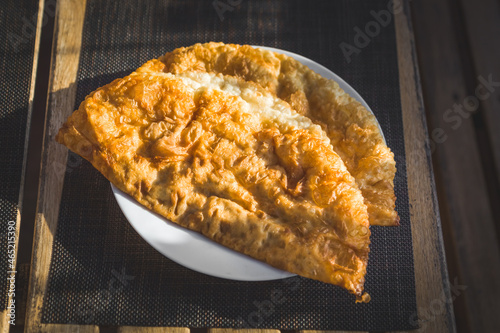 two chebureks with meat on a plate photo