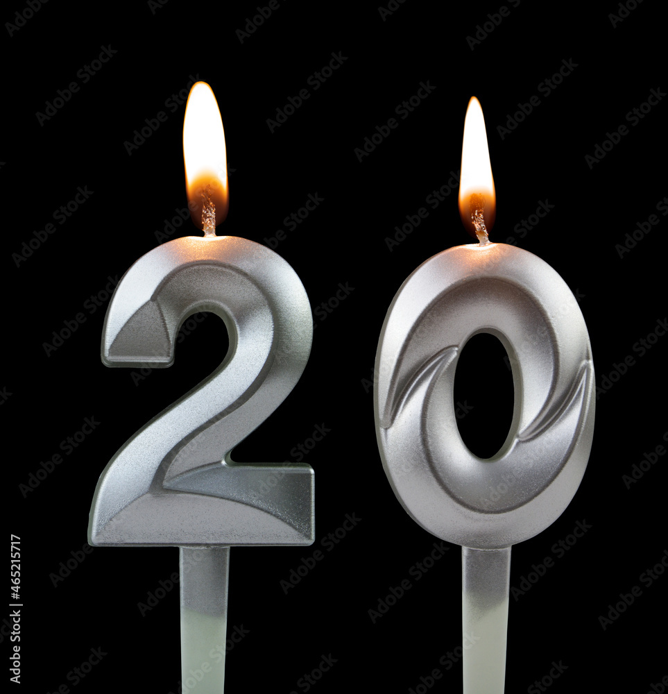 Burning silver birthday candle isolated on black background, number 20 Burning silver birthday candle isolated on black background, number 20