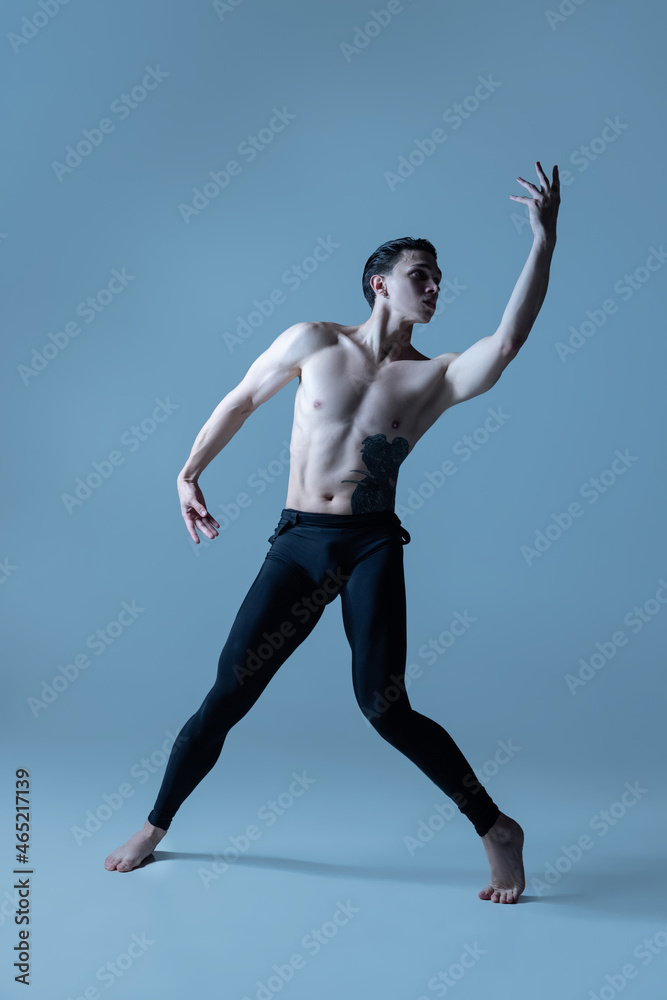 Obraz premium Young and graceful male ballet dancer isolated on old navy studio background. Art, motion, action, flexibility, inspiration concept.