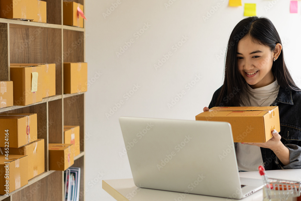 Portrait of a Small Business Startup, SME Owner, Asian Female Entrepreneur Work on receipt boxes and check online orders to prepare the boxes. Selling to customers. Online SME business idea. Portrait of a Small Business Startup, SME Owner, Asian Female Entrepreneur Work on receipt boxes and check online orders to prepare the boxes. Selling to customers. Online SME business idea.