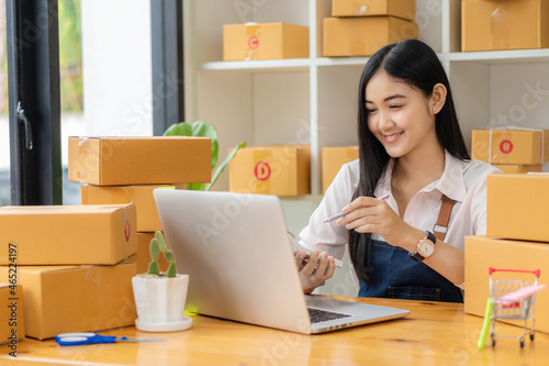 Portrait of a Small Business Startup, SME Owner, Asian Female Entrepreneur Work on receipt boxes and check online orders to prepare the boxes. Selling to customers. Online SME business idea.