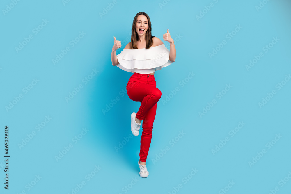 Fototapeta premium Full body photo of positive young happy cheerful lady lift thumb up good mood isolated on blue color background