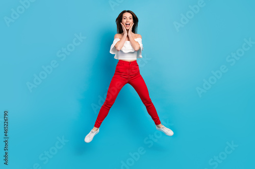 Full length body size view of attractive cheerful lucky amazed girl jumping having fun isolated over bright blue color background