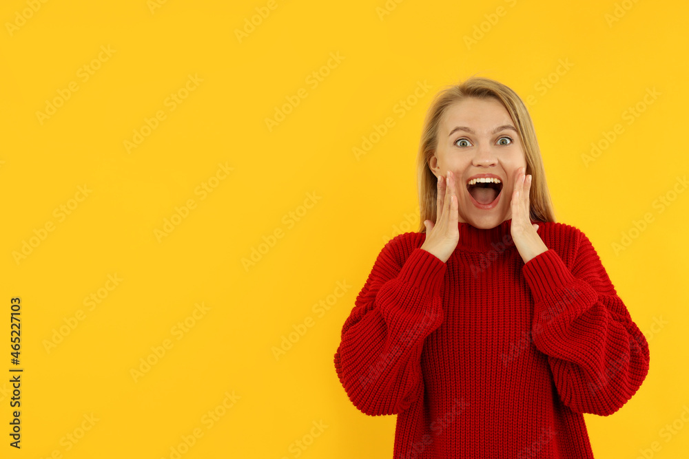 Attractive young woman in red sweater on yellow background Attractive young woman in red sweater on yellow background