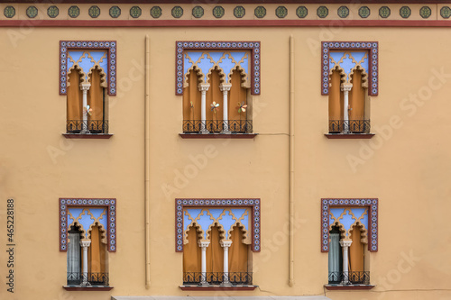 Detailed view of the exterior facade of a Moorish-style building, Arabic architecture with decorative elements, arabic multifoil arches and decorative tiles, in Córdoba city photo