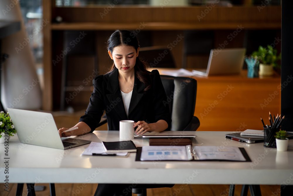 Shot of a asian young business Female working on laptop computer in her workstation.Portrait of Business people employee freelance online marketing e-commerce telemarketing concept. Shot of a asian young business Female working on laptop computer in her workstation.Portrait of Business people employee freelance online marketing e-commerce telemarketing concept.