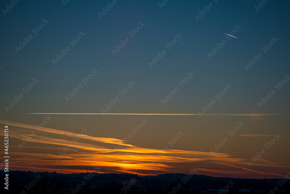 Romantic cloudscape of evening sky in Vilnius, Lithuania. Vibrant colors, feather like clouds, stunning sunset. Selective focus on the details, blurred background.