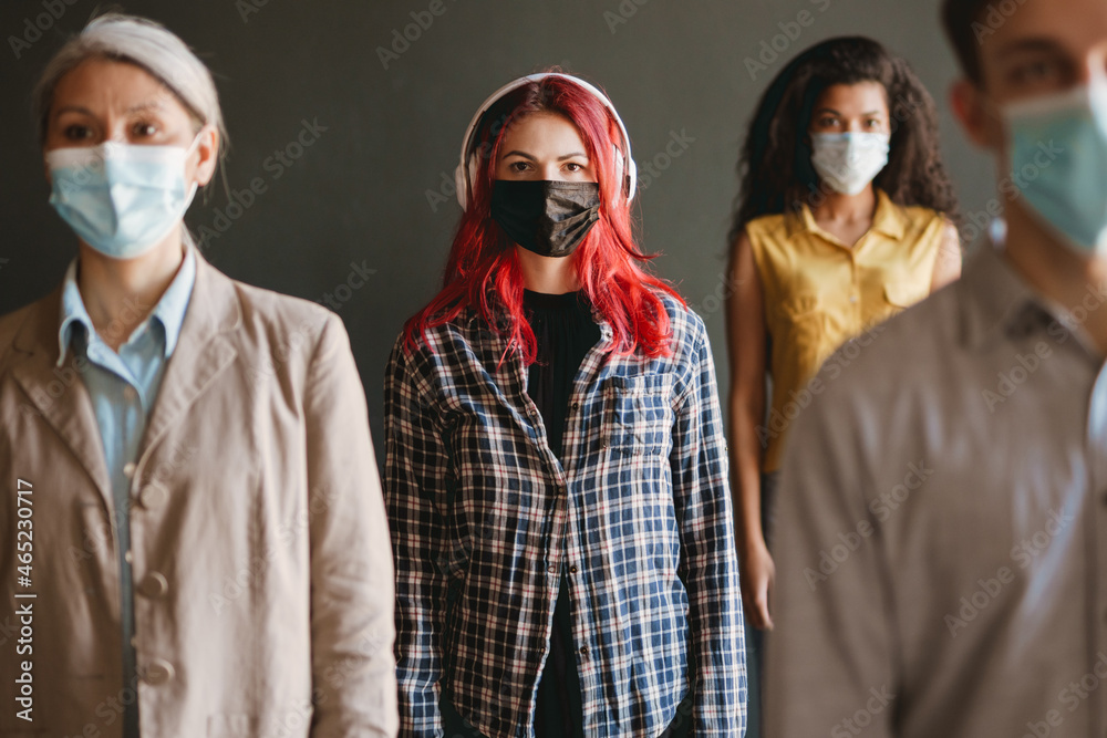 Multiracial man and women in face mask looking at camera