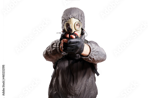 An isolated shot of a man dressed in a gas mask, a hooded jacket, a backpack, gloves, holding a gun and aiming straight. On a white isolated background