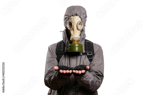An isolated shot of a man dressed in a gas mask, a jacket with a hood, a backpack, holding the palms of his hands parallel to the floor in front of him as if there was something in them. On a white