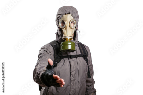 An isolated shot of a man dressed in a gas mask, a hooded jacket, a backpack, reaching out for a handshake, looking into the camera. On a white isolated background