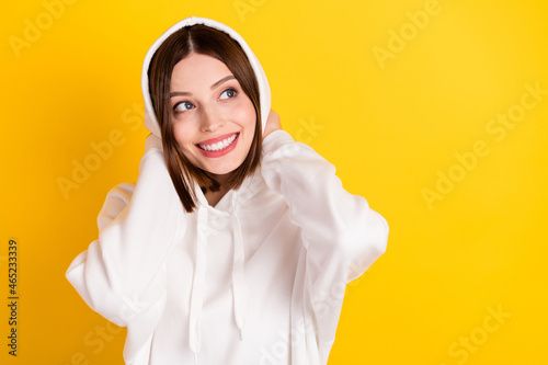 Photo of lovely dreamy lady look empty space touch hood wear white hoodie isolated yellow color background