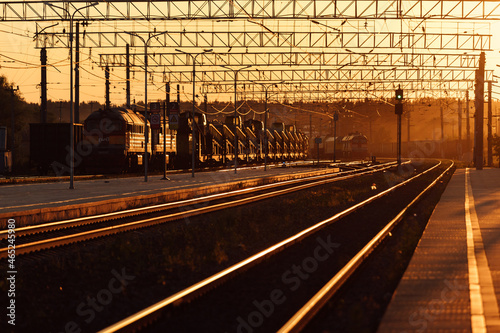 railway platform at sunset. a deserted provincial railway station. beautiful golden light of the sun at sunset. travel time by train