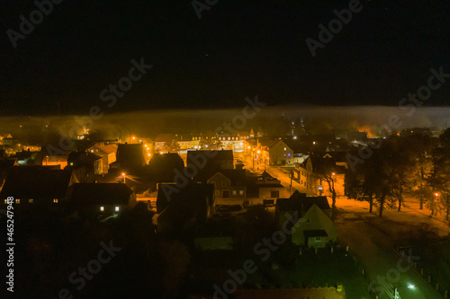 Panorama małego miasteczka Iłowa położonego w Polsce. Jest noc. Ciemności rozświetla światło latarni. Widok z drona.