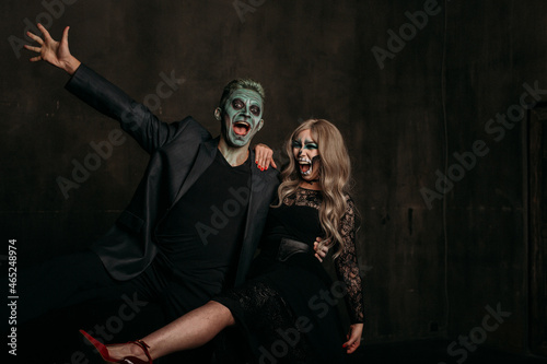 The image of a skeleton girl and the image of a Frankenstein man on Halloween in the dark. an image for a couple on Halloween. fooling around and laughing