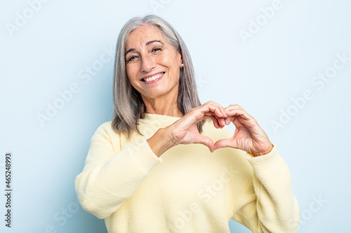 Bild auf Leinwand middle age gray hair woman smiling and feeling happy, cute, romantic and in love