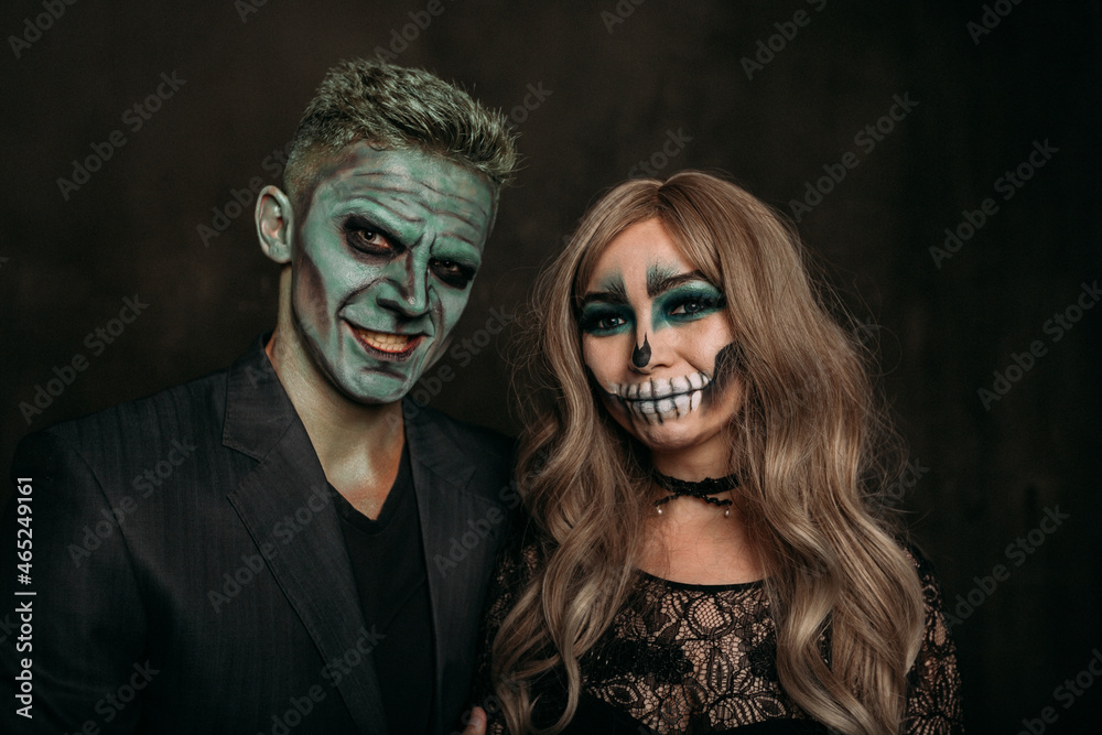 The image of a skeleton girl and the image of a Frankenstein man on Halloween in the dark. an image for a couple on Halloween. Both laugh