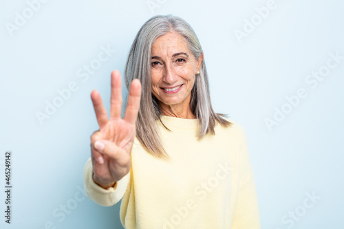 Fotografie middle age gray hair woman smiling and looking friendly, showing number three or