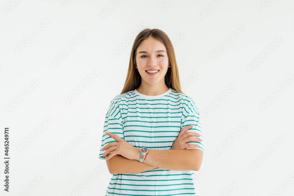 Portrait of a happy woman standing with arms folded on a white background