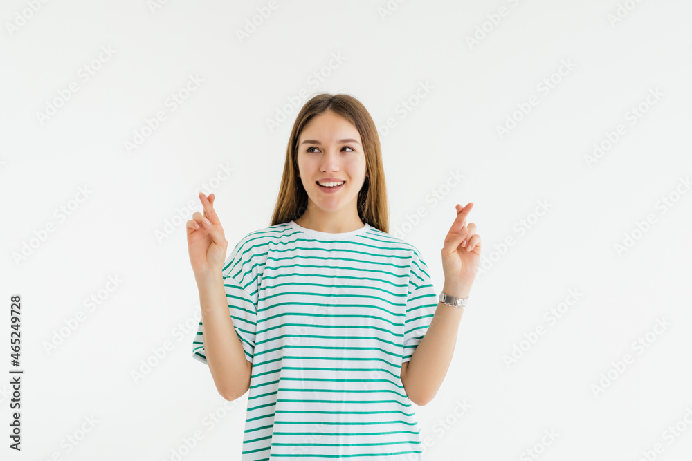 Young woman with fingers crossed, isolated on white. Concept of wishing or praying about something Young woman with fingers crossed, isolated on white. Concept of wishing or praying about something