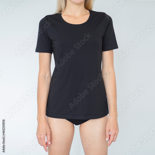 Mockup of black feminine t-shirt. Woman wears cotton casual underwear. Copy space Template for clothes, lingerie, on a nude model, for presentation of design, imprint
