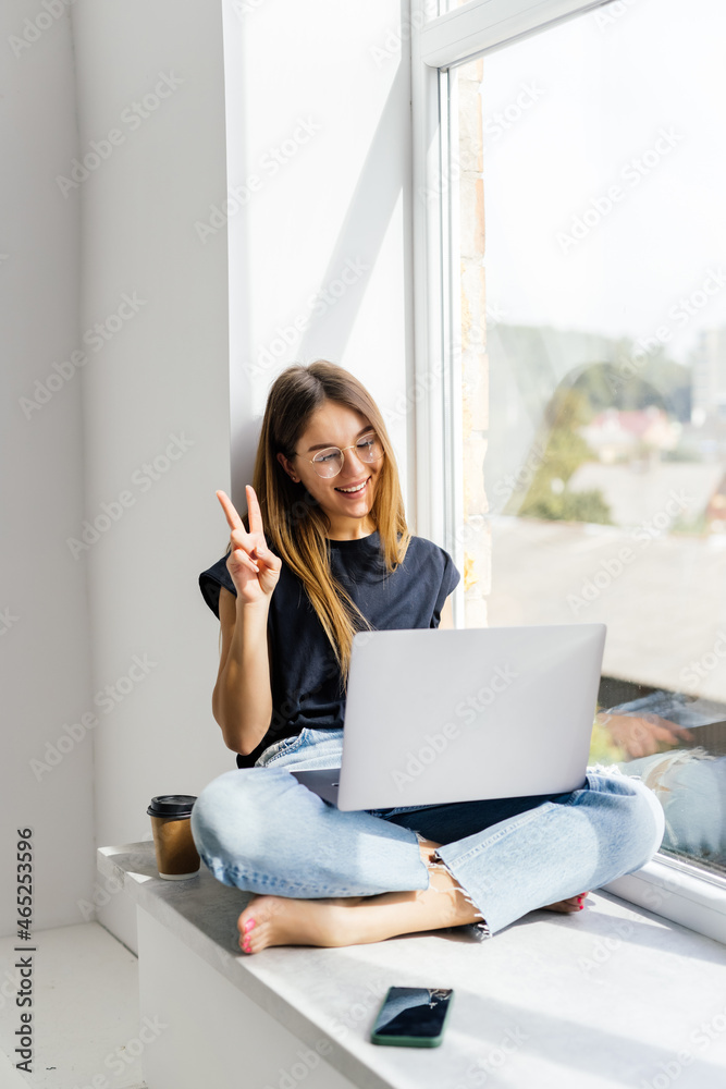 Young pretty woman have video call on laptop from home office Workplace on the windowsill. Young pretty woman have video call on laptop from home office Workplace on the windowsill.