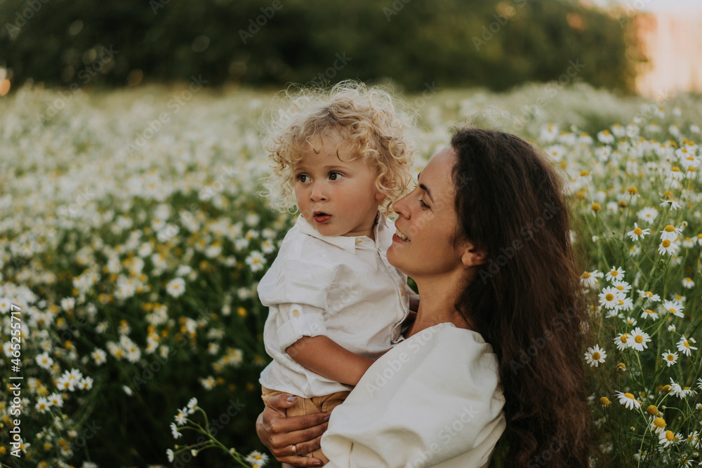 Smiling woman carrying blond baby boy at field Smiling woman carrying blond baby boy at field