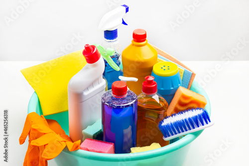 Set of household chemicals for cleaning the apartment in green plastic bowl.