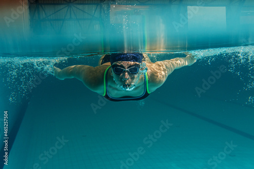   Female swimmer in sports outfit at the swimming pool.Underwater photo.  