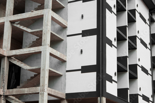 the picture shows the construction of a highrise building. tall black and white house. concrete building construction concept