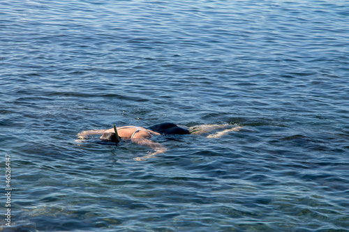 Adult woman diving into clear water of sea