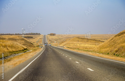 Road and moving cars at daytime and blue sky over