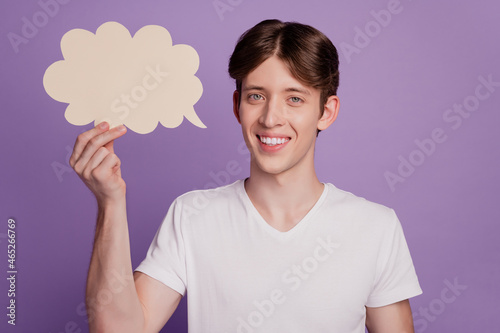 Portrait of positive cheerful guy hold white paper card cloud think news isolated over purple color background