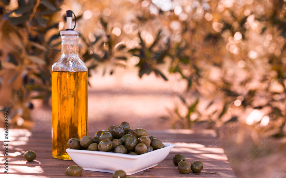 green olives and oil on table in olive grove green olives and oil on table in olive grove