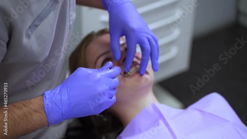 Dentist visiting at hospital. Young woman undergoes examining of teeth with skilled doctor spbas at appointment in professional clinic office closeup photo