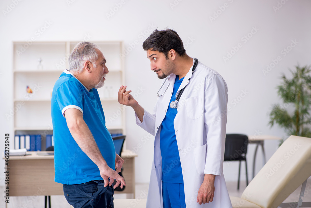 Old male patient visiting young male doctor Old male patient visiting young male doctor