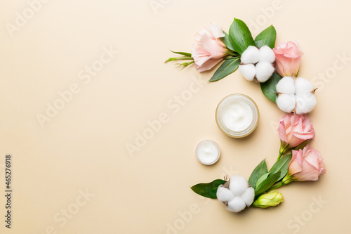 Composition with cosmetic products and beautiful roses on color background. Copy space, flat lay