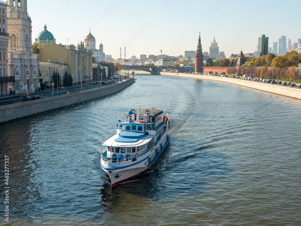 Moscow, Russia - October 5, 2021: View from the Moskvoretsky bridge to the Moscow river with a sailing ship and the Kremlin embankment.